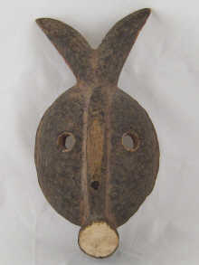 A carved wooden tribal mask with