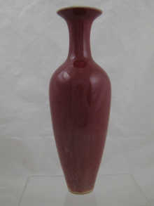 A tall red glazed Chinese vase with