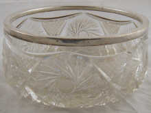 A cut glass salad bowl with silver