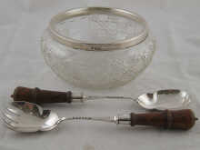 A cut glass salad bowl with silver