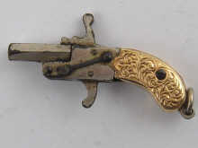 A miniature pistol with yellow metal