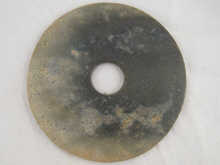 A Chinese green hardstone bi 23 cm diameter.