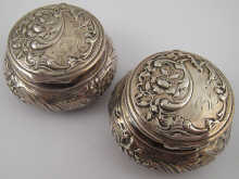 A pair of silver circular boxes
