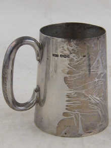 A silver mug of tapering form with C