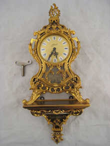 A gilt mechanical alarm clock on conforming