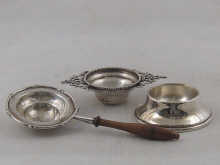 A silver two handled tea strainer