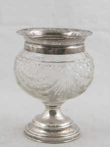 A silver mounted cut glass vase on silver