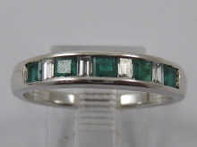 A diamond and emerald half hoop