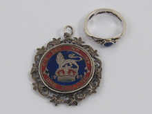 An enamelled silver shilling mounted