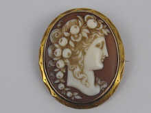A carved shell cameo brooch set in yellow