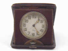 A leather cased travelling clock circa