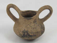 An antique squat turned pot with long