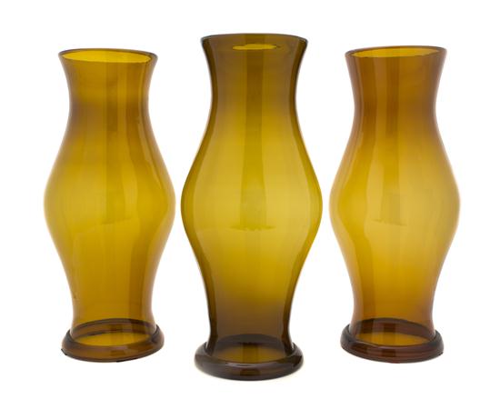 A Set of Three Amber Glass Hurricane