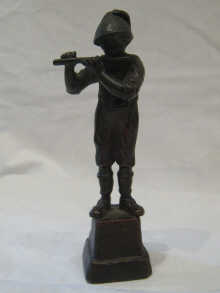 A bronze figure of a boy playing the