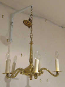 A brass five arm chandelier with electric