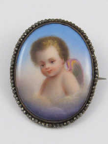 A porcelain brooch depicting a cherub
