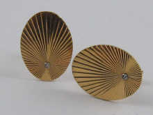 A pair of oval cufflinks with sunburst