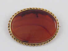 An oval agate brooch set in yellow