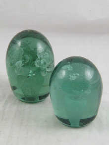 Two green glass dump paper weights (one