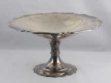 A silver cake stand with scroll