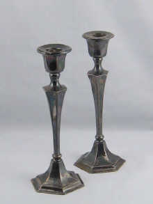 A pair of silver candlesticks measuring