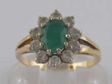 An emerald and white stone ring