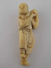 An antique ivory netsuke of a Chinese