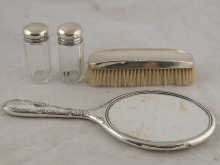 A silver hand mirror silverclothes brush