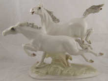 A ceramic group of two prancing