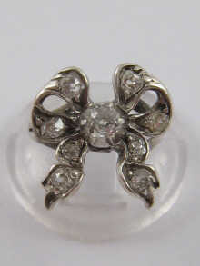 A white metal antique diamond bow