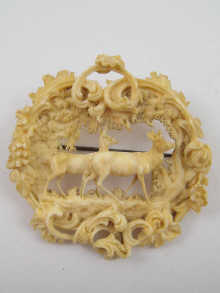 A finely carved ivory brooch depicting