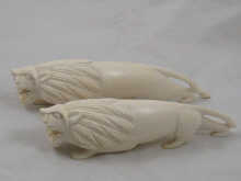 A pair of carved ivory lions each