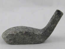 An antique stone golf club head