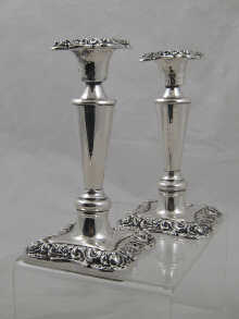 A pair of silver candlesticks measuring