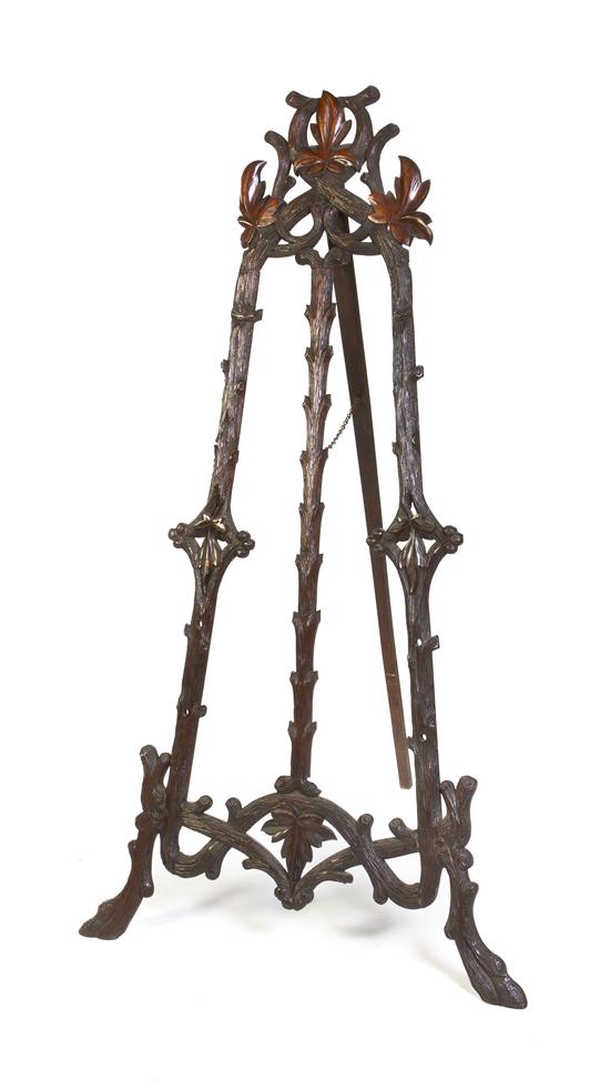 A Black Forest Carved Easel of triangular