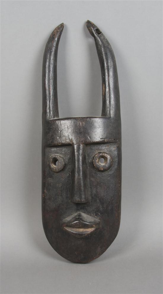 A Carved Wood Mask Toma depicting