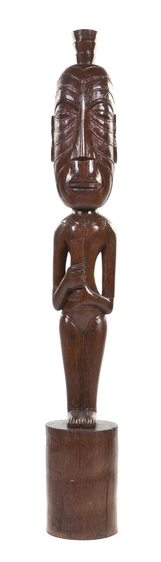 A Carved Wood Tiki depicted standing
