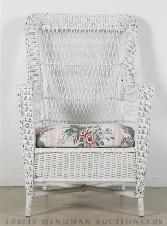 A Painted Wicker Armchair raised on