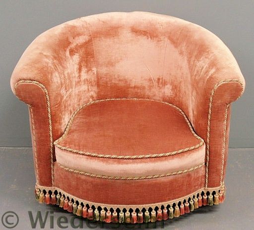 Pink upholstered barrel-back armchair.