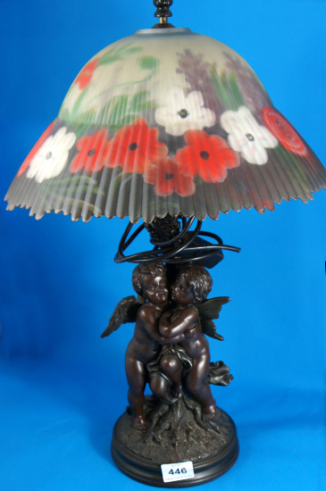 A lamp base decorated with cupids standing