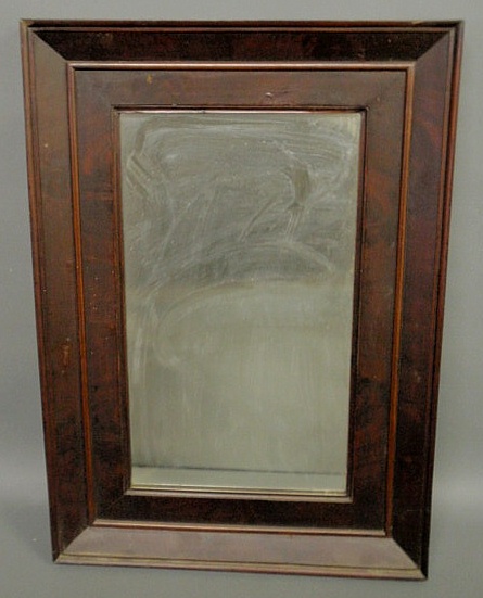 Mirror with a mahogany veneered frame.