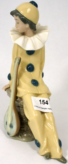 Nao figure of a seated boy harlequin