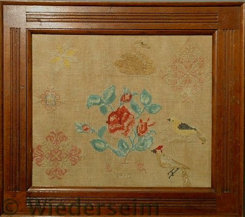 Needlework of a spray of roses surrounded