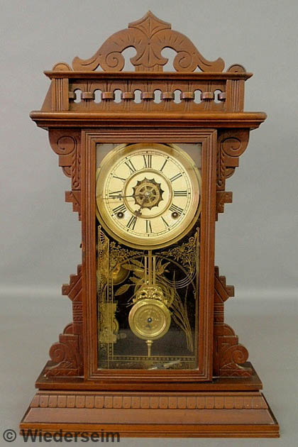 Carved walnut shelf clock by Waterbury