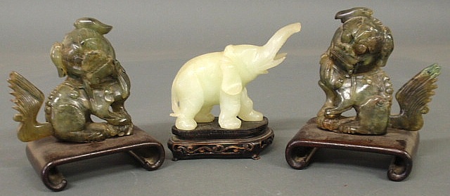 Two spinach jade foo dogs set on scrolled