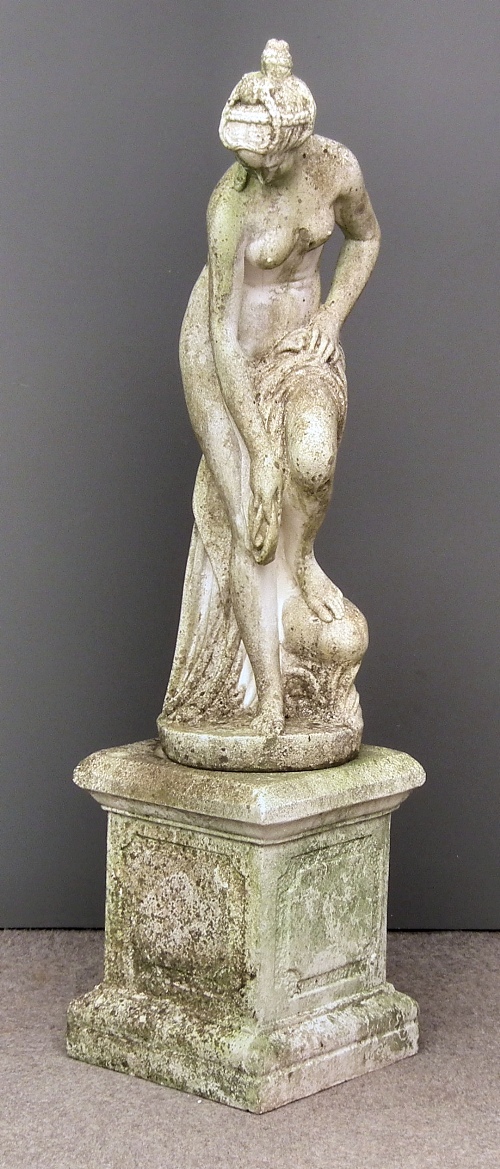 A concrete statue of a semi nude woman