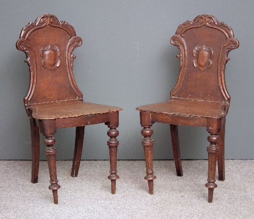 A pair of Victorian oak hall chairs