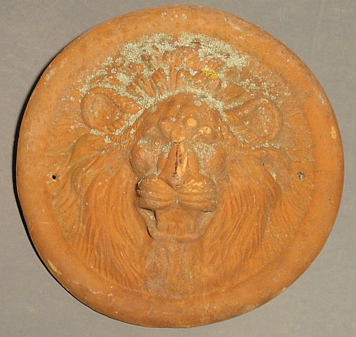 Round terracotta lion head mask.