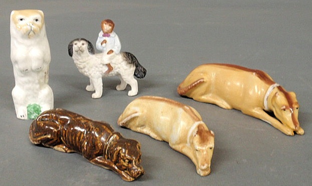 Three porcelain whippets and two other