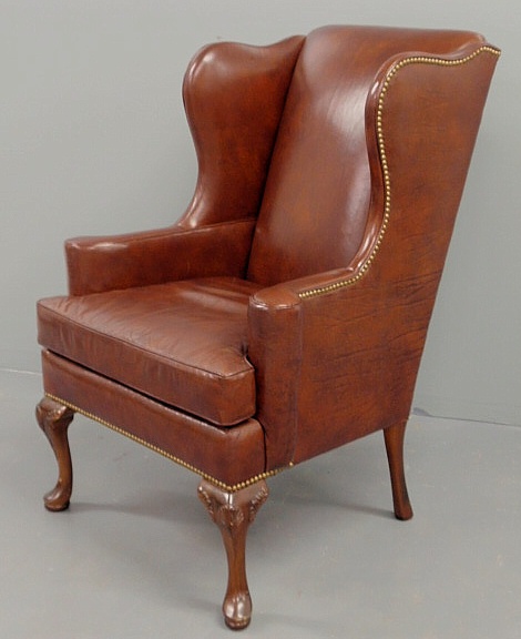 Queen Anne style red leather wing chair.